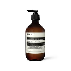 Aesop Eleos hand balm jar close-up showing rich, hydrating texture for dry hands.