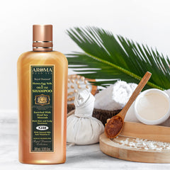 Olive oil bottle beside AR0MA DEAD SEA shampoo emphasizing shine