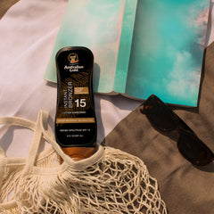 Australian Gold bottle highlighting water resistance and bronze glow.