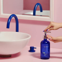 Capri Blue hand wash bottle on sink with stylish bathroom decor.