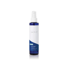 Capri Blue Volcano dry oil spray bottle pouring for quick, non-greasy hydration.