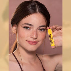 COCOCARE lip balm being applied to lips to hydrate and soften.