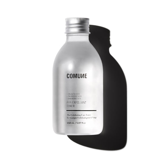 COMUNE AHA Exfoliant Toner bottle pour showing gentle exfoliation and pore refinement.