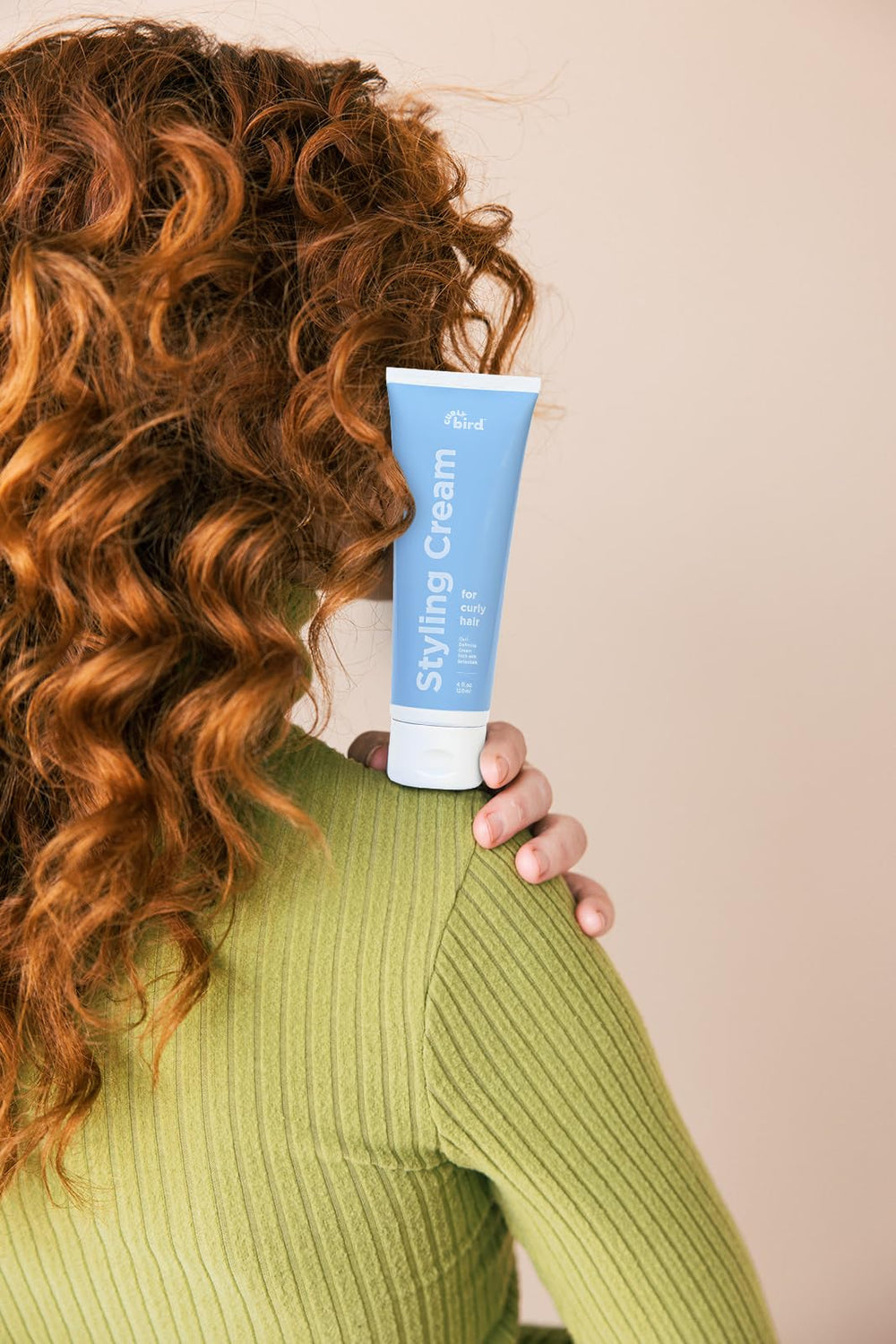 Distributing cream through wet hair to shape curls