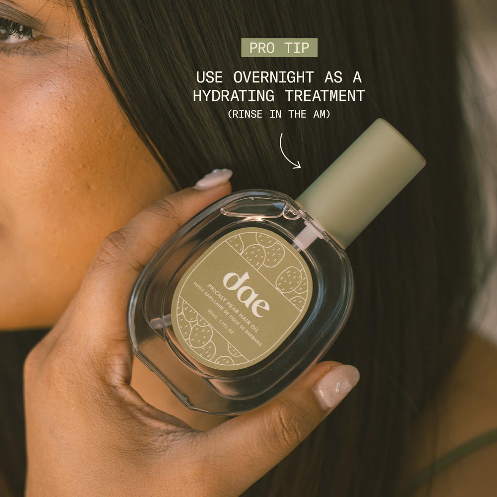 Hands apply DAE Prickly Pear Oil to damp hair
