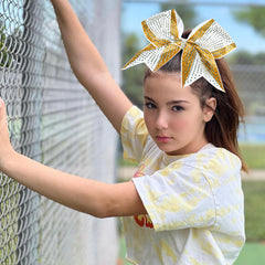 DEEKA team-ready gold and white bow complements uniforms and performances.