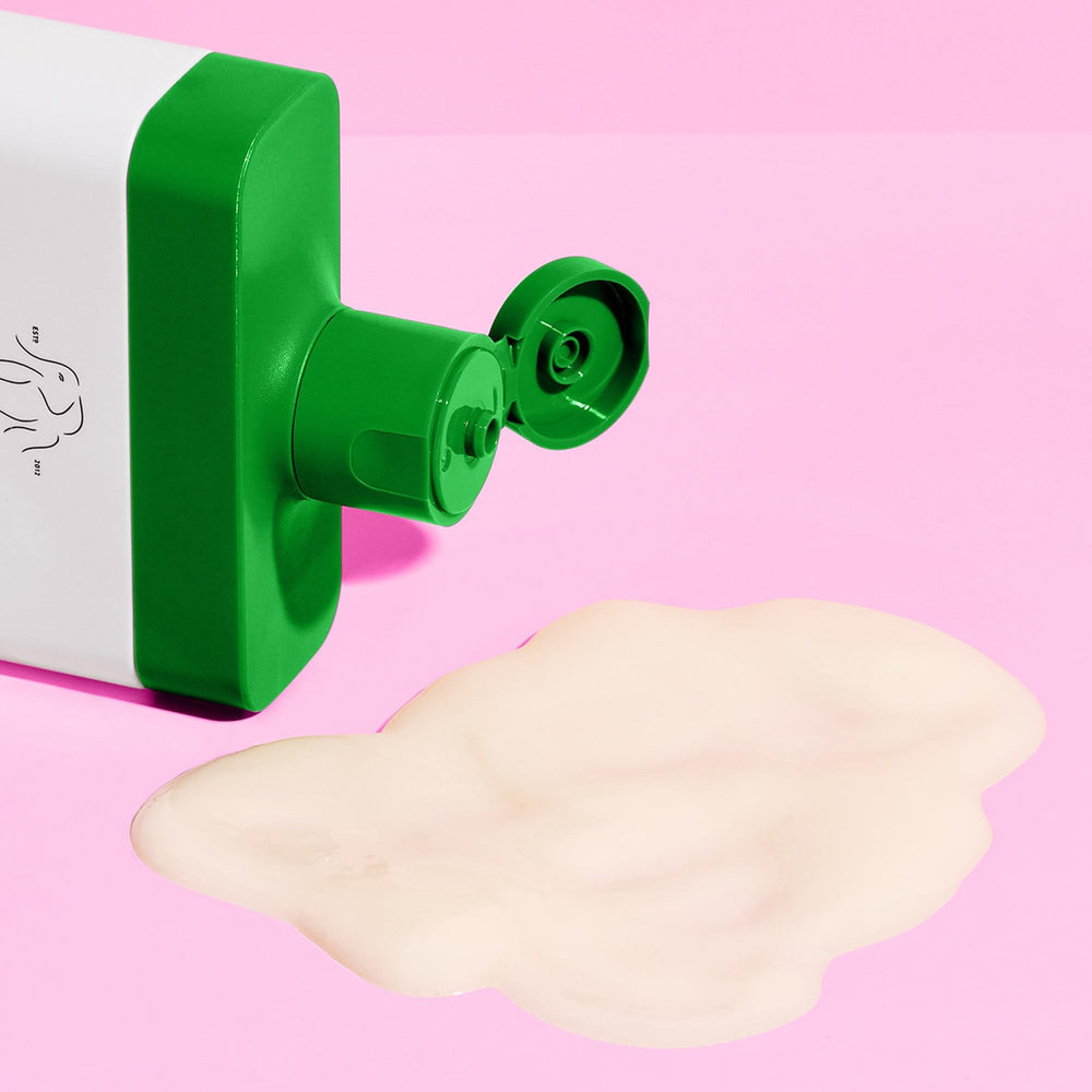 Hands applying Silkamino shampoo, rich lather forms without harsh sulfates.