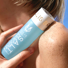 Lifestyle beach scene with Ellis Brooklyn SALT Body Oil conveying coastal luxury and daily self-care.
