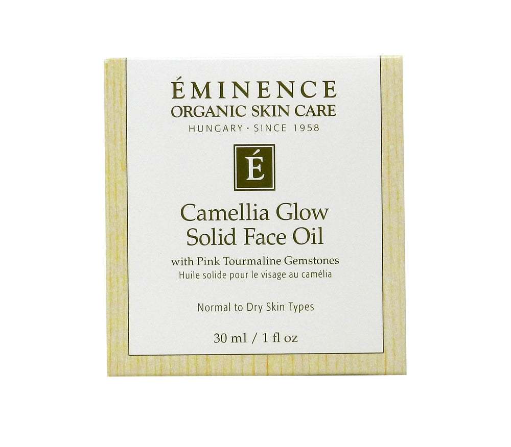 Eminence Camellia Glow solid oil in palm ready to melt onto skin.