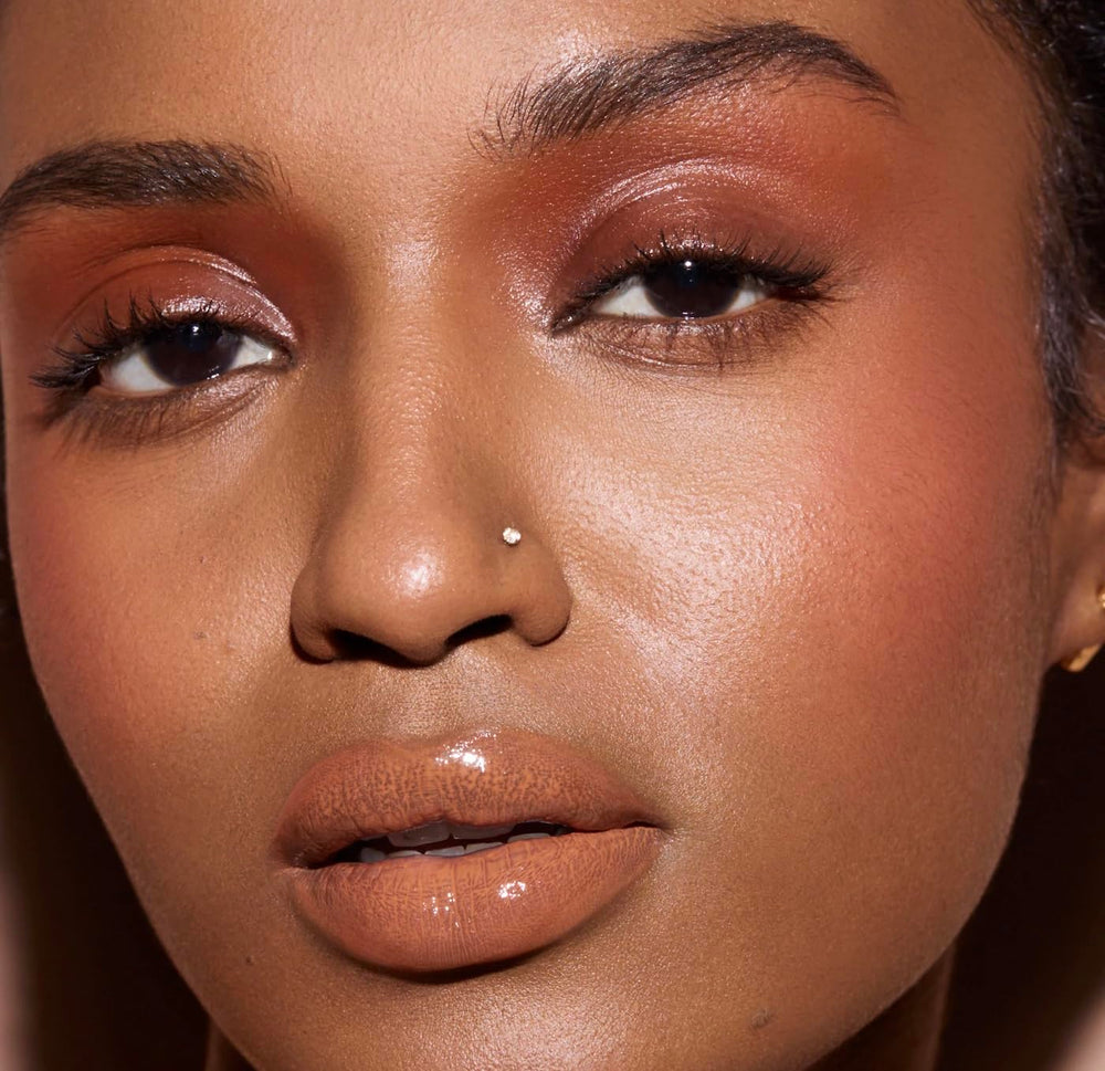 FENTY BEAUTY Gloss Bomb Cream Color Drip Honey Waffles glossy finish on lips.