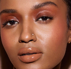 FENTY BEAUTY Gloss Bomb Cream Color Drip Honey Waffles glossy finish on lips.