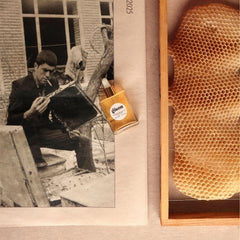 Gisou Honey Infused Hair Oil Mini bottle beside bee garden oil blend.