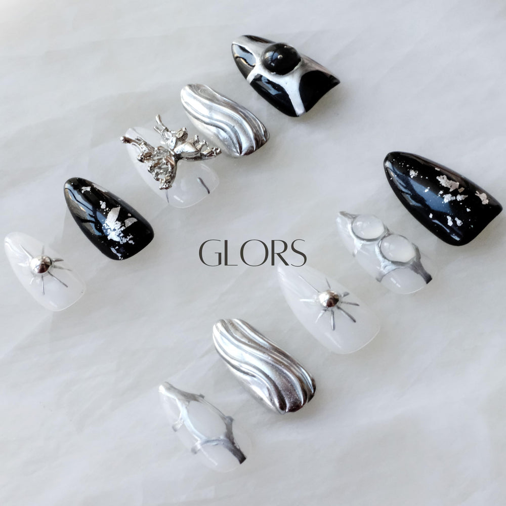 GLORS Gothic long almond nails with a metallic butterfly accent for whimsical glamour