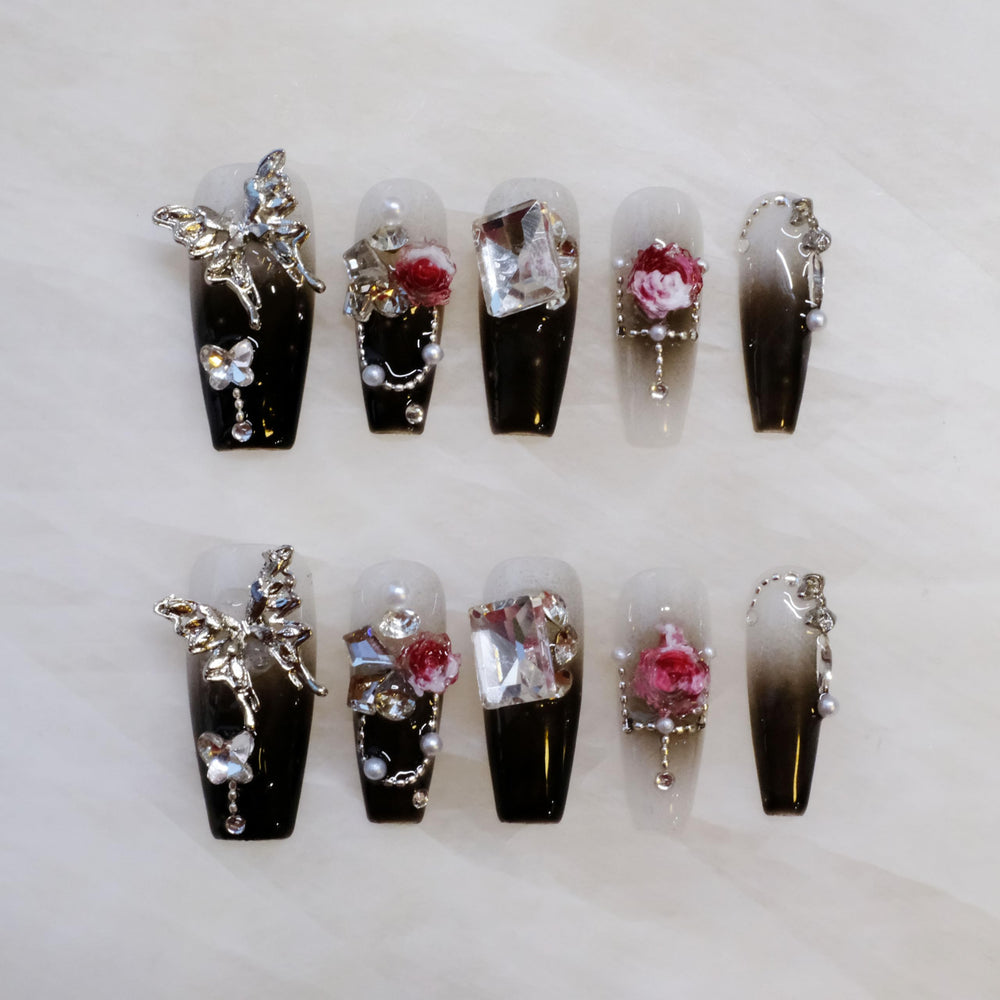 GLORS handmade press-on nails with butterfly and rose accents for dramatic night-out style.