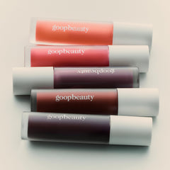 Goop Hydra-Barrier Gel Gloss wand applying plump, shiny color.