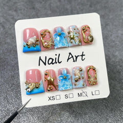 Handmade press-on nails featuring blue flower embossing for chic daytime wear.