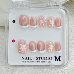 Handmade press-on nails: white French tips with flower designs for a polished look.