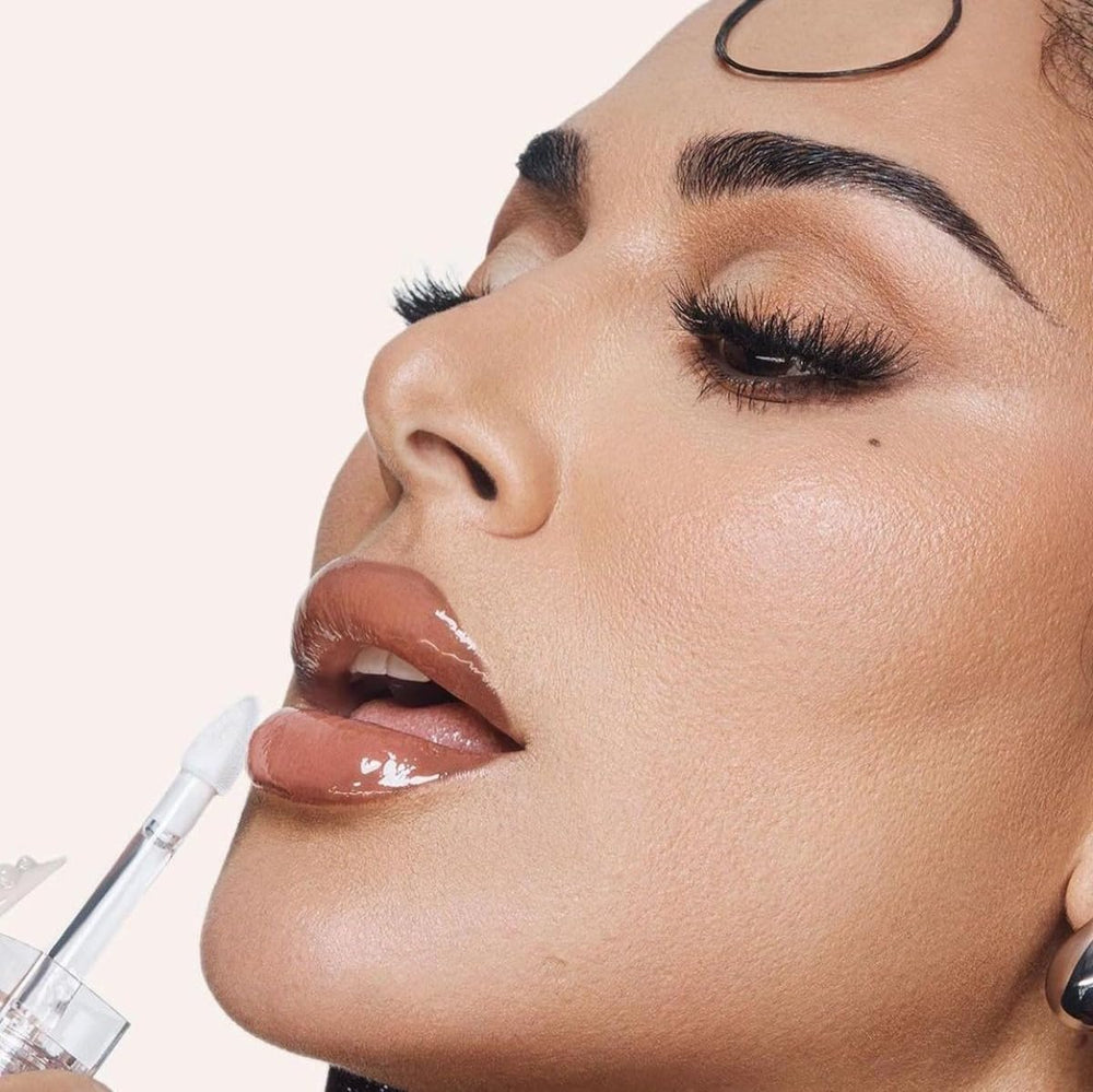 Huda Faux Filler Extra Shine Lip Gloss Glassy on lips for glassy, hydrating finish.
