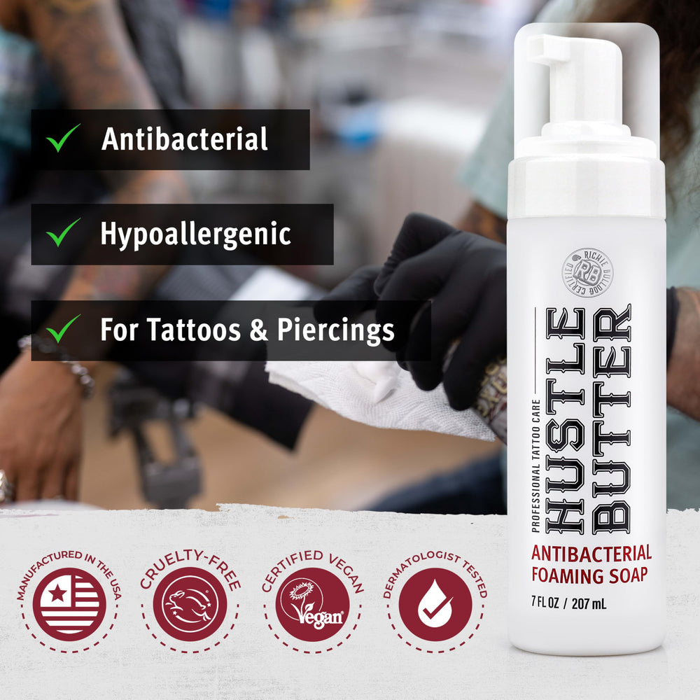 Hand applying Hustle Bubbles foam to tattooed area during healing.