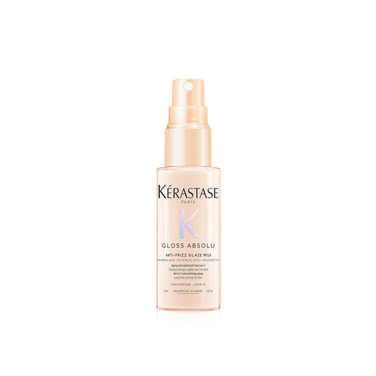 Kerastase Gloss Absolu Glaze Milk bottle on desk, highlighting detangling and smoothness for long hair.