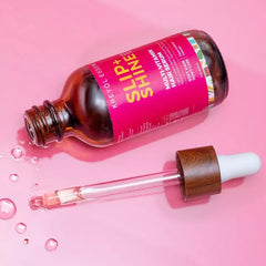 KREYÒL ESSENCE Protect + Shine serum being applied to hair for smooth strands.