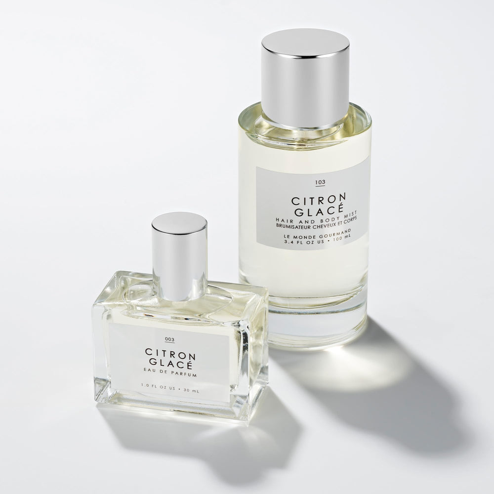 Le Monde Gourmand Citron Glacé bottle on a vanity with warm glow.