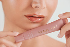 Makari Vanilla Beige lip balm on makeup bag display.