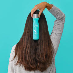A hand holds Malibu C Scalp Wellness Shampoo for everyday use.