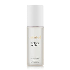 Mented Better Setter spray bottle releasing a fine makeup-setting mist.