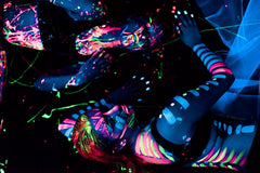 Midnight Glo green UV neon paint creates glowing designs at night events.