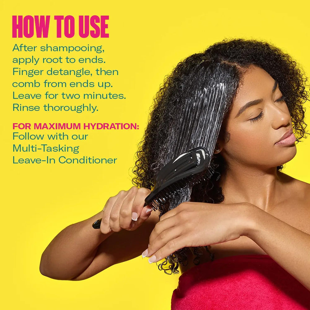 Detangling wet, conditioned curls with a wide-tooth comb.