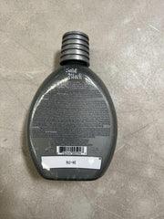 Millennium Tanning Solid Black 13.5 oz bottle shown beside sunlit setup