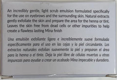 Hands apply the scrub along the brow line before tinting.