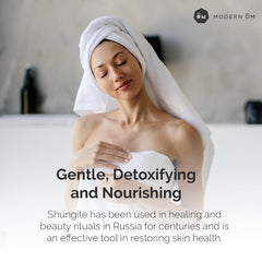 Modern ŌM Shungite Recharge Body Wash being applied for gentle cleansing.