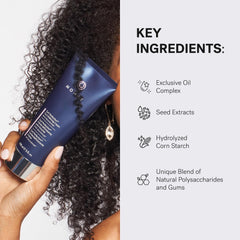 Hands applying MONAT Curl Perfection Cream to damp curls