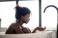 Spa-like soak scene with fizzing bath bomb in tub.