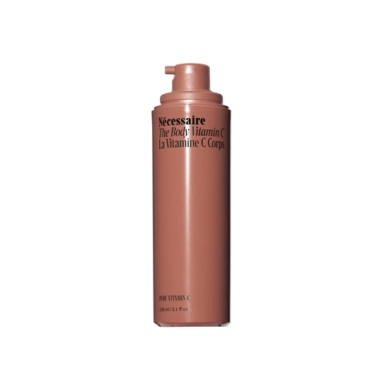 Nécessaire The Body Vitamin C Serum bottle on a vanity for daily radiance.