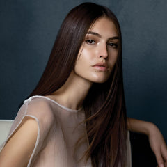 Hair appears smoothed with frizz control after spray.