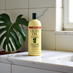 ORS Olive Oil Replenishing Conditioner on a bathroom surface demonstrates real life use