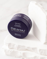 Hands applying Pai-Shau Molded balm for quick styling.