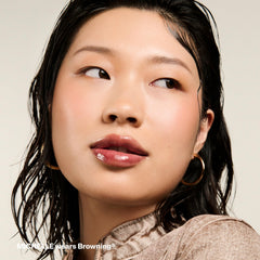 Pound Cake Cake Theory color-neutralizing lip oil evens tone with violet-brown tint.
