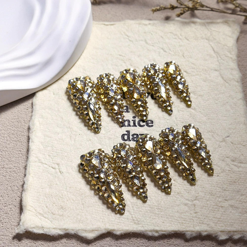 Qicaijia almond press-on nails with long gold rhinestones for glamorous everyday wear