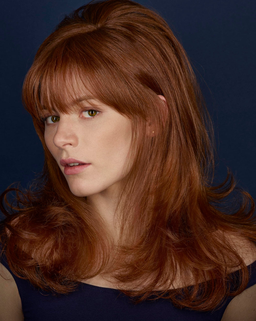 Hands apply BLEU mist on damp hair to reduce frizz and add softness