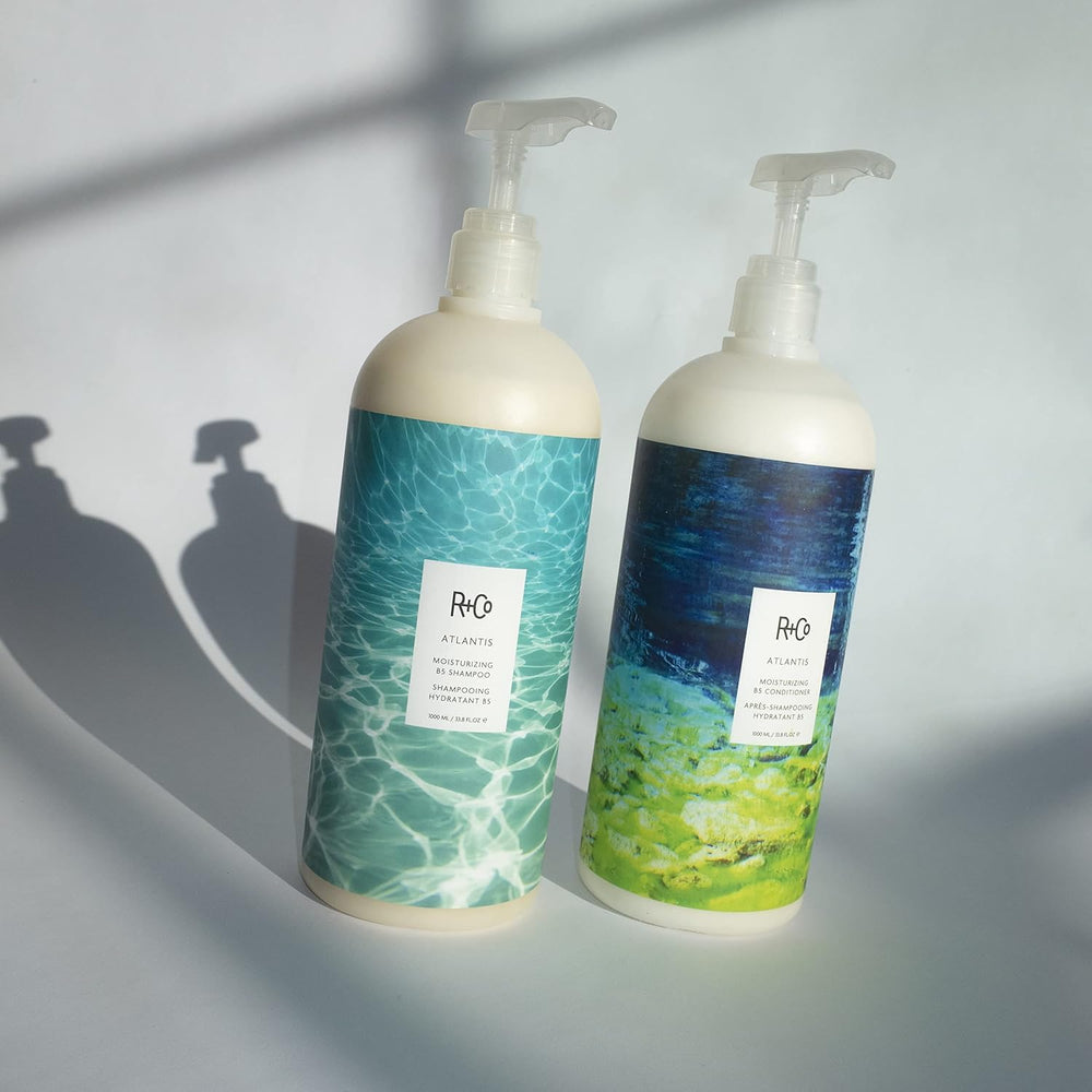 R+Co Atlantis bottle pour demonstrates easy application during shower.