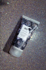 Application shot of R+Co Gemstone Ultra Shine glossing on damp hair.
