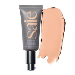 Saie Slip Tint bottle pour showing a dewy glow and easy application