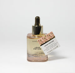Sand + Fog Love Potion dropper application shown for easy, lasting fragrance