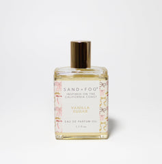 Sand + Fog Vanilla Sugar bottle with pink and gold accents, elegant coastal fragrance.