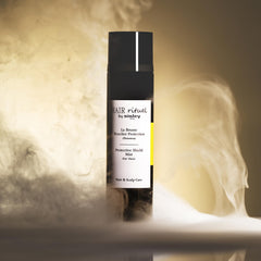 Sunny outdoor scene shows Sisley Protective Shield Mist shielding hair from sun.