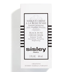 Applying Sisley Paris Black Rose Cream Mask to face and neck for a refreshed look.
